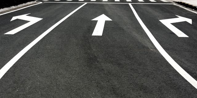 In the picture, the arrows on the road are used for: